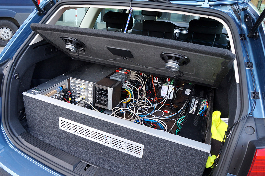 Ein Auto mit vielen Kabeln und Computern im Kofferraum verbaut.