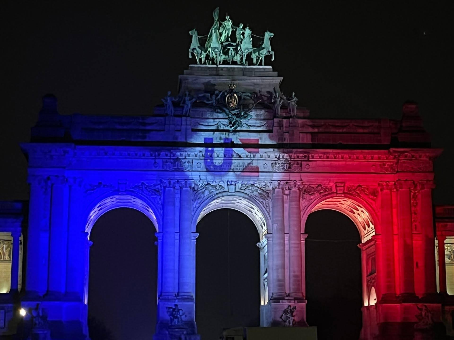 Ein Torbogen beleuchtet in den Farben der französischen Nationalflagge
