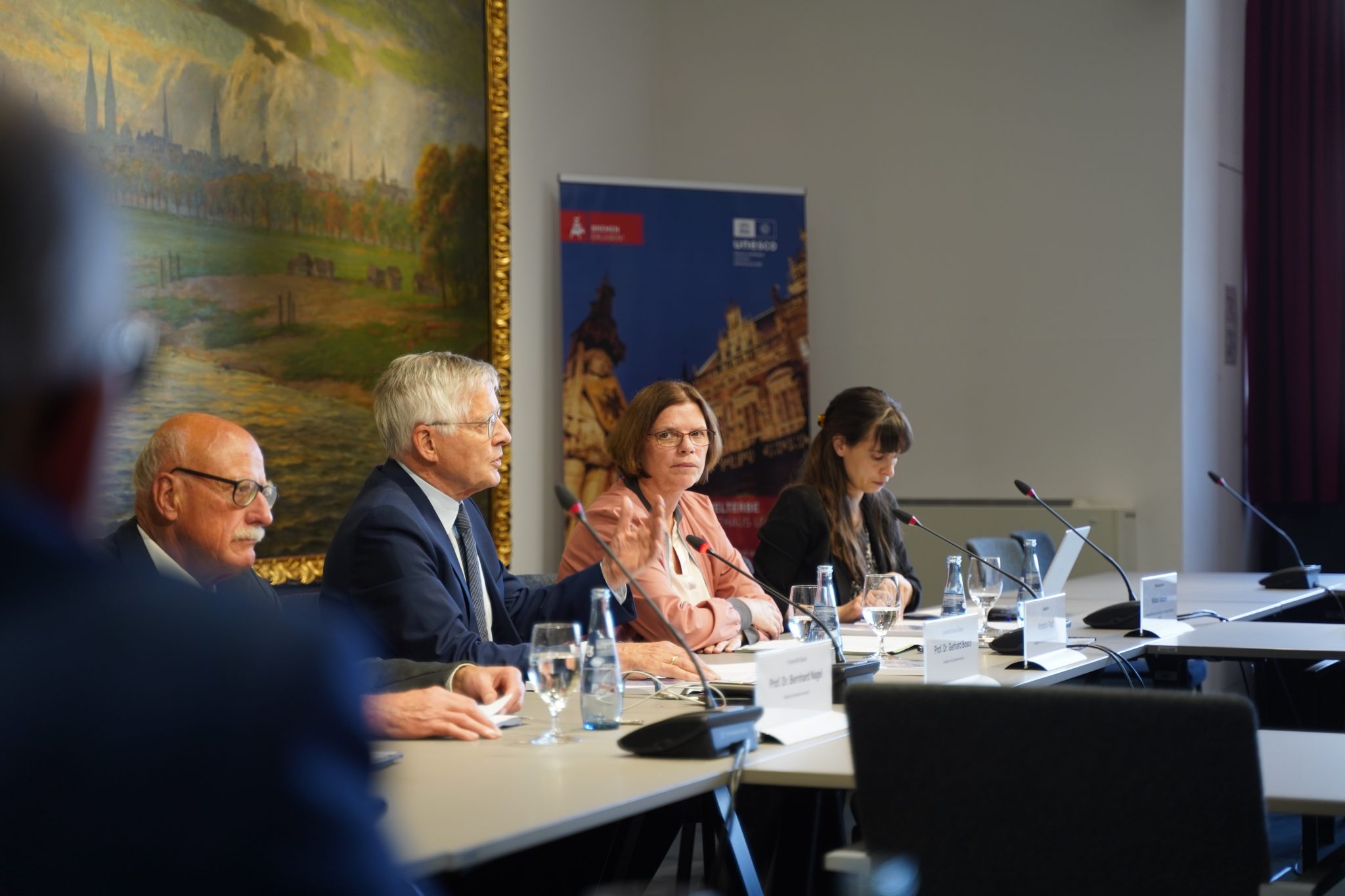 Senatorin Vogt und weitere Personen sitzen an einem Diskussionspodium