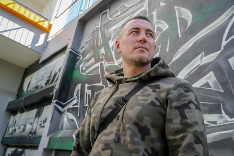 Daniel Magel steht vor einer Grafitti-Wand