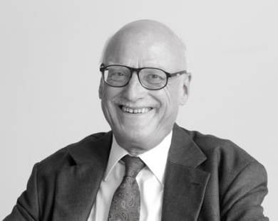 Das Bild eines älteren lächelnden Mannes mit Brille. Das Bild ist schwarz-weiß