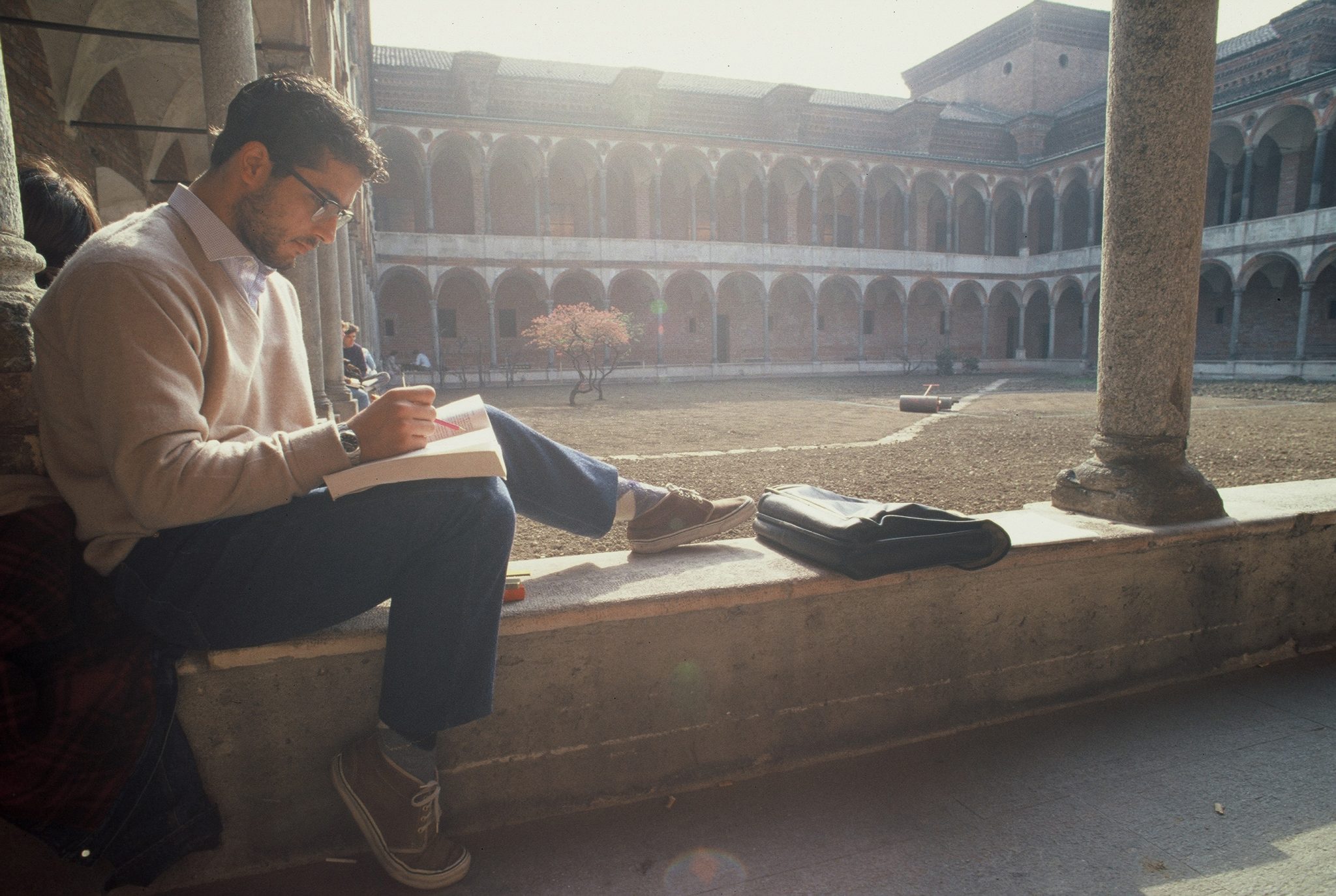 Ein Mann sitzt auf einer Fensterbank und liest ein Buch