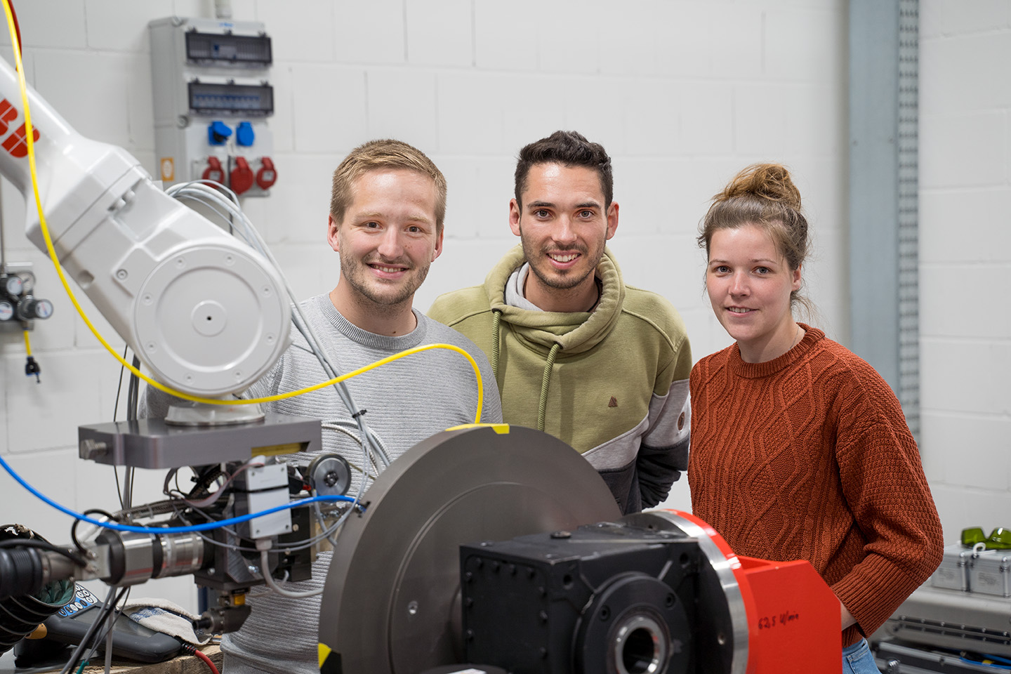 Thorsten Mattulat, Marcel Möbus und Anika Langebeck aus dem Projektteam vor dem Schweißroboter, Bild: WFB/Raveling