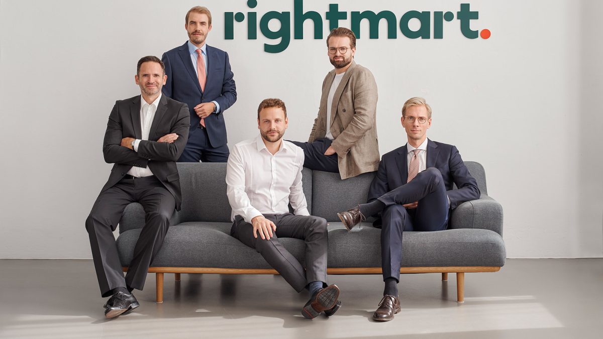 Fünf Männer in Anzügen sitzen auf einer Couch. Im Hintergrund ist das Logo von rightmart. zu sehen.
